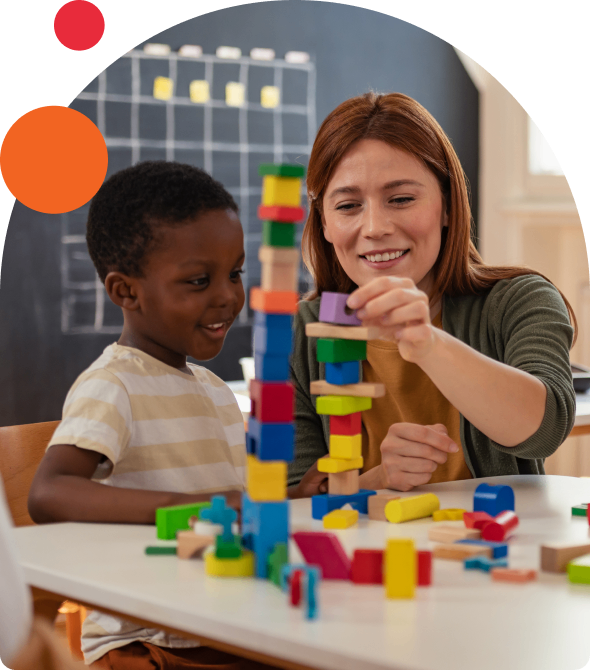 Child and teacher stacking colorful blocks